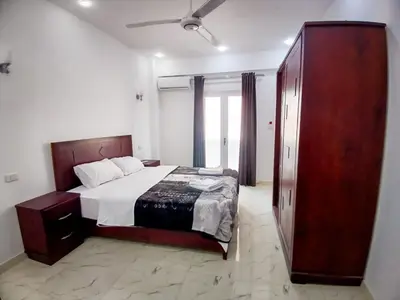 a bedroom with a bed and a large wooden cabinet at Sky Guest House in Luxor