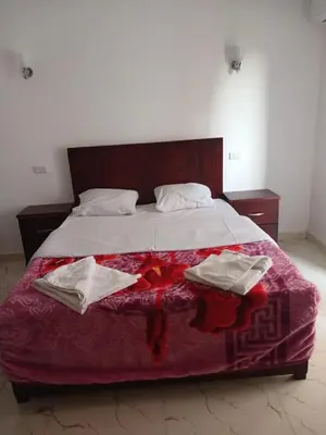 a large bed with two towels on top of it at Sky Guest House in Luxor