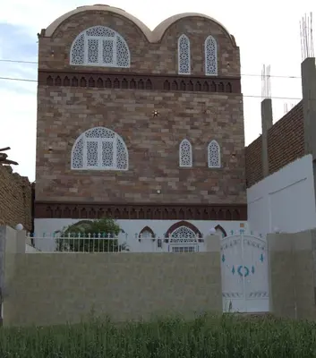a large brick building with a fence in front of it at Mogran Guest House in Luxor