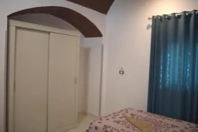 a bedroom with a closet and a blue curtain at Mogran Guest House in Luxor