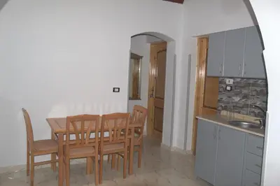a kitchen and dining room with a table and chairs at Mogran Guest House in Luxor