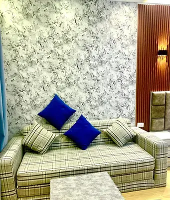a couch with blue pillows in a living room at Sunny studio with 3 swimming pools Florenza Hurghada in Hurghada