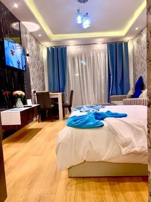 a bedroom with a bed and a desk and a television at Sunny studio with 3 swimming pools Florenza Hurghada in Hurghada