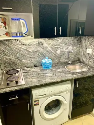 a kitchen counter with a washing machine and a sink at Sunny studio with 3 swimming pools Florenza Hurghada in Hurghada