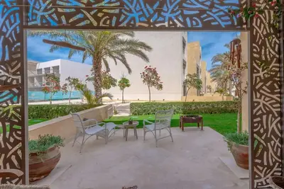 a patio with chairs and a table in a yard at Mangroovy - Spacious Boho 2 BR Pool view in Hurghada