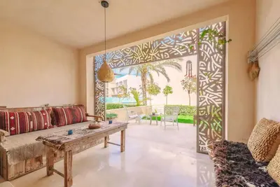 a living room with a couch and a table at Mangroovy - Spacious Boho 2 BR Pool view in Hurghada