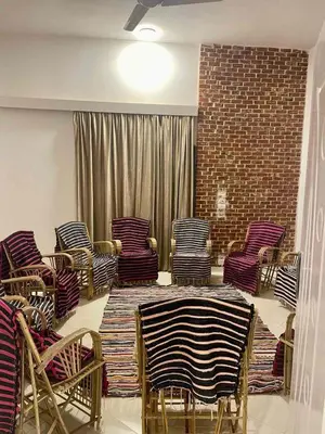 a room with chairs and a table and a brick wall at Karima House in Luxor