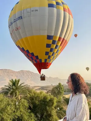 a woman is looking at a hot air balloon at Karima House in Luxor