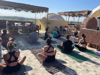 a group of people sitting on the ground doing yoga at Karima House in Luxor