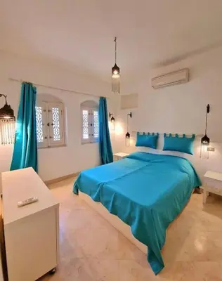 a bedroom with a blue bed and blue curtains at Cozy apartment in Downtown Gouna in Hurghada