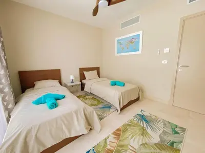 a bedroom with two beds with blue pillows on them at Cozy 1 Bedroom Ground Floor Apartment with Pool in Hurghada