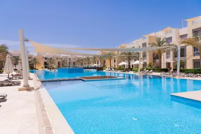 a large swimming pool with blue water in a resort at Cozy 1 Bedroom Ground Floor Apartment with Pool in Hurghada