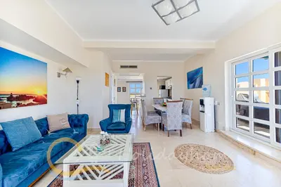 a living room with a blue couch and a table at 2-BR Penthouse with roof terrace in Abu Tig Marina in Hurghada