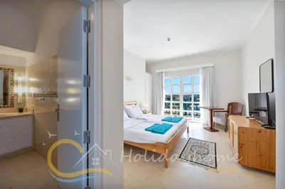 a bedroom with a bed and a kitchen at 2-BR Penthouse with roof terrace in Abu Tig Marina in Hurghada