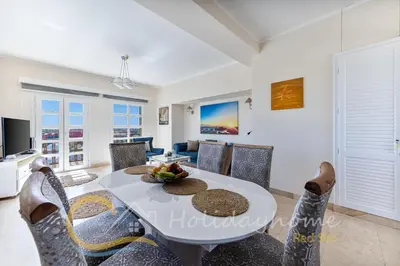 a dining room and living room with a table and chairs at 2-BR Penthouse with roof terrace in Abu Tig Marina in Hurghada