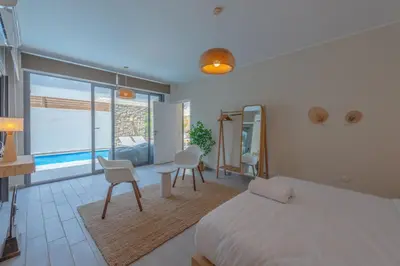 a bedroom with a bed and chairs and a large window at Tropical 2BR Paradise in Bali, El Gouna. Pool, Patio & BBQ in Hurghada