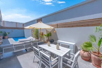 a patio with a table and chairs and a pool at Tropical 2BR Paradise in Bali, El Gouna. Pool, Patio & BBQ in Hurghada