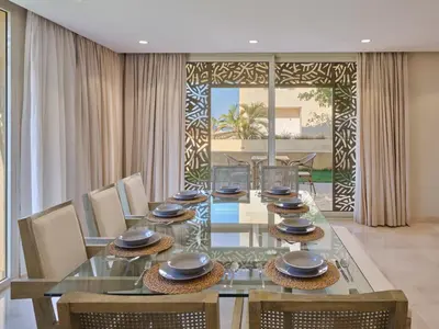a dining room with a glass table and chairs at Boutique Residence Mangroovy-Lemon Spaces Gouna in Hurghada