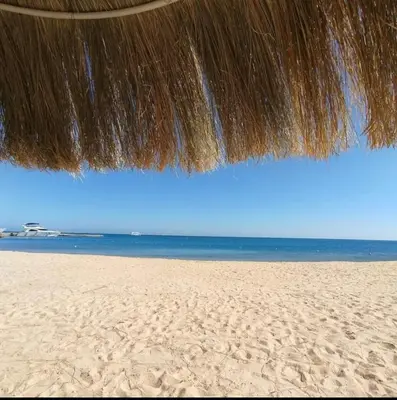 a close up of a straw umbrella on a beach at Princess resort in Hurghada