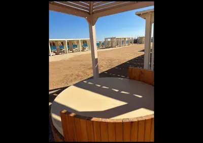 a table and chairs under an umbrella on the beach at Princess resort in Hurghada