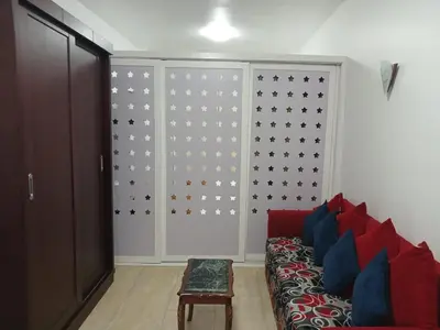 a living room with a red couch and a wall at Turtle beach apartment in Hurghada
