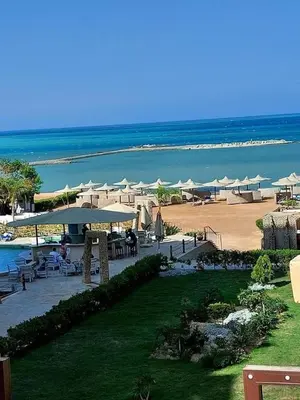 a resort with a beach with umbrellas and the ocean at Turtle beach apartment in Hurghada