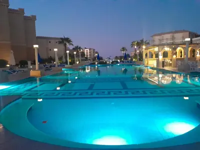 a large swimming pool at night with blue lights at Selena bay in Hurghada