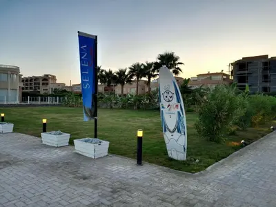 a surfboard on display in a park with a flag at Selena bay in Hurghada