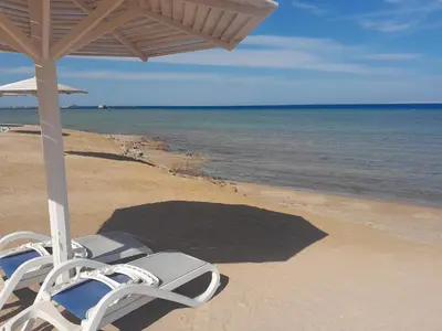 a pair of chairs sitting on the beach at Selena bay in Hurghada