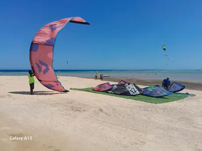 a group of people on the beach flying kites at Selena bay in Hurghada