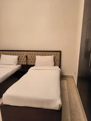 a bedroom with two beds with white sheets at Roof top apartment with panorama view in Hurghada