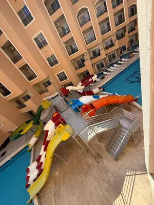 a hotel swimming pool with a water slide and chairs at Juliana resort beach - Julia apartment in Hurghada