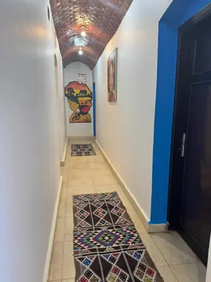 a hallway with a tile floor and a hallway with a rug at king kassem nubian guest house in Aswan