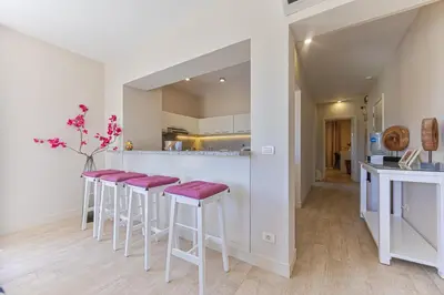 a kitchen with a bar with red stools at Cheerful space with a huge garden and pool in Hurghada