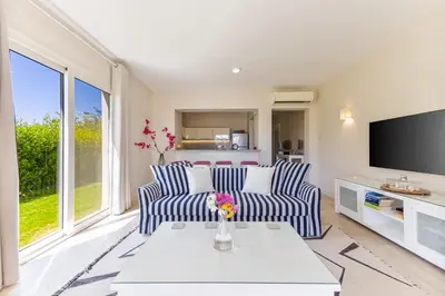 a living room with two blue and white chairs and a tv at Cheerful space with a huge garden and pool in Hurghada
