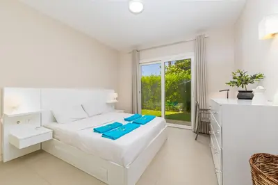 a white bedroom with a large bed and a window at Cheerful space with a huge garden and pool in Hurghada