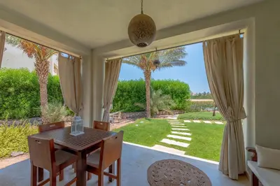 a dining room with a table and a view of a yard at 1-Bedroom Apartment in Joubal with nice Pool in Hurghada
