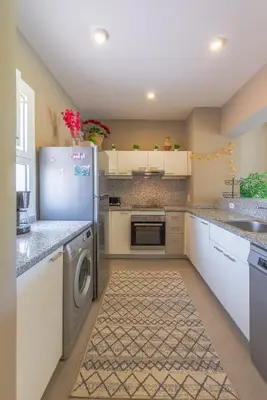 a kitchen with a refrigerator and a dishwasher at 1-Bedroom Apartment in Joubal with nice Pool in Hurghada