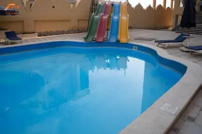a large swimming pool with a inflatable pool toy at FOX SAHEL AQUA RESORT ELGOUNa& Kite in Hurghada