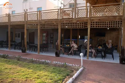 a group of people sitting at tables on a patio at FOX SAHEL AQUA RESORT ELGOUNa& Kite in Hurghada