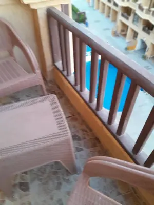 a stair railing with a chair and a swimming pool at Turtles beach resort hourghada studio view sea view pool private beach jacuzzi security air-conditioned Cafe restaurant on the beach and a large sunny balcony in Hurghada
