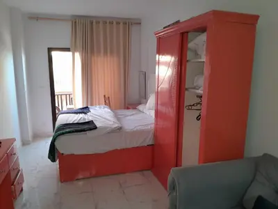a bedroom with a red cabinet with a bed at Turtles beach resort hourghada studio view sea view pool private beach jacuzzi security air-conditioned Cafe restaurant on the beach and a large sunny balcony in Hurghada