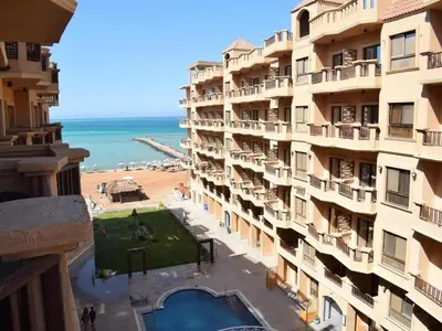 a view of the beach from the balcony of a building at Turtles beach resort hourghada studio view sea view pool private beach jacuzzi security air-conditioned Cafe restaurant on the beach and a large sunny balcony in Hurghada