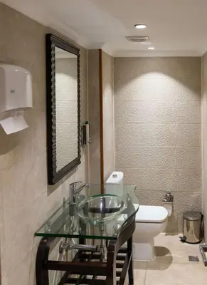 a bathroom with a glass sink and a toilet at Sonesta Moon Goddess Cruise Ship From Luxor to Aswan - 04 & 07 nights Every Monday in Luxor