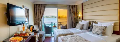 a hotel room with two beds and a television at Sonesta Moon Goddess Cruise Ship From Luxor to Aswan - 04 & 07 nights Every Monday in Luxor