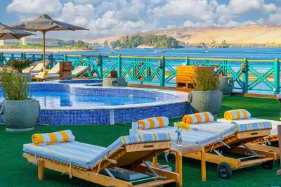 a pool with chaise lounge chairs and a swimming pool at Sonesta Moon Goddess Cruise Ship From Luxor to Aswan - 04 & 07 nights Every Monday in Luxor
