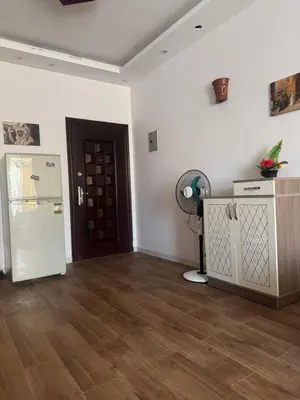 a living room with a refrigerator and a wooden floor at Inter Prime apartment 2 in Hurghada