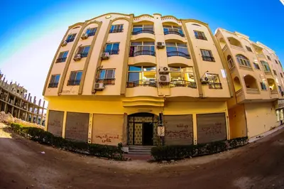 a yellow building sitting on the side of a street at Inter Prime apartment 2 in Hurghada