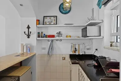 a kitchen with white walls and a counter top at The Seafront Magical Loft! in Hurghada
