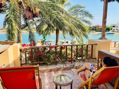 a woman sitting in a chair on the balcony of a resort at The Seafront Magical Loft! in Hurghada